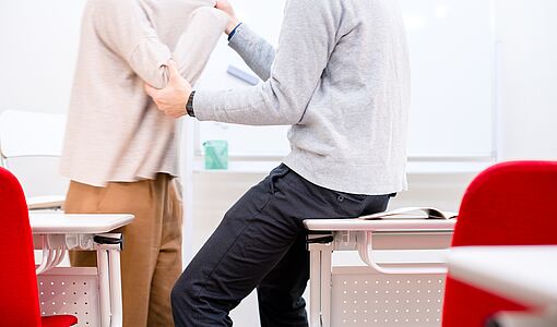 Zwei Männer streiten sich im Klassenzimmer