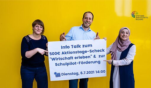 3 Personen mit Infoplakat