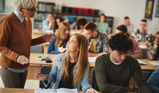 Schülerin diskutiert mit Lehrerin in einer Klasse