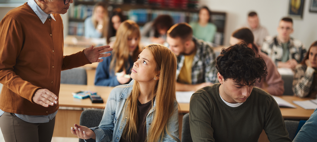 Schülerin diskutiert mit Lehrerin in einer Klasse