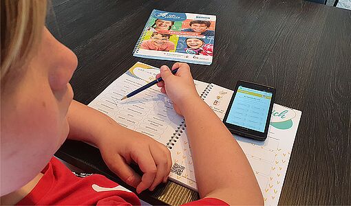 Ein Schüler beim Arbeiten mit dem Berufsorientierungsheft "Ich werde"