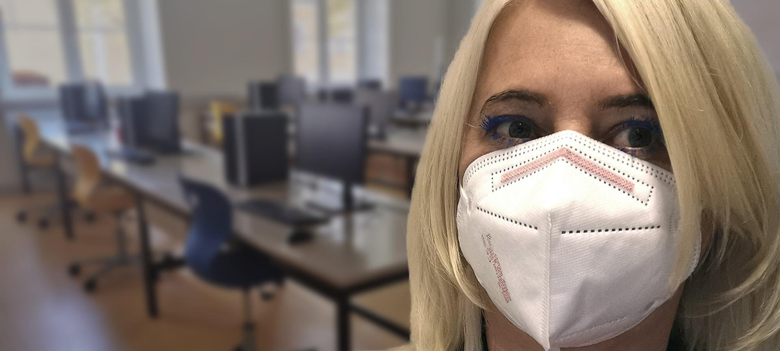 Lehrerin mit FFP2 Maske in leerer Klasse