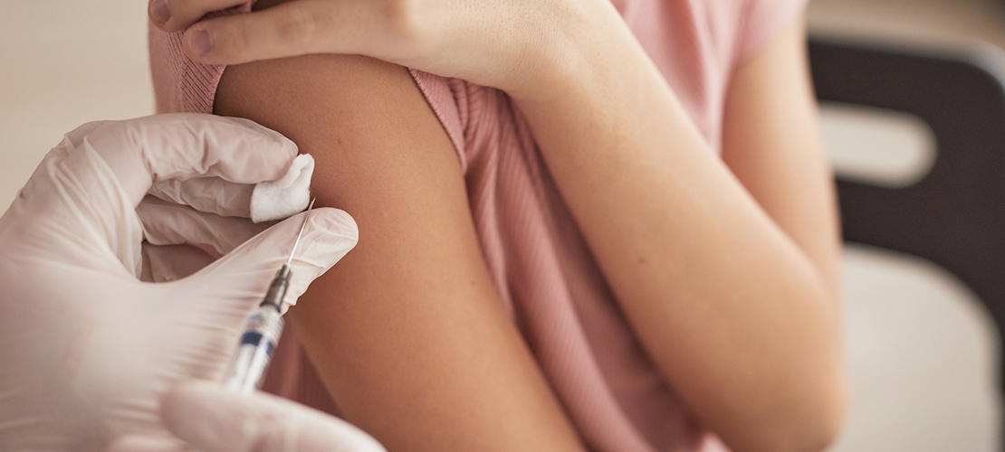 Impfung in den rechten Oberarm eines Mädchens