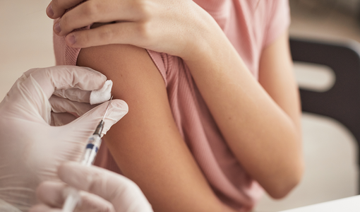 Impfung in den rechten Oberarm eines Mädchens