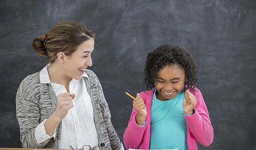 Schülerin lacht mit Lehrerin