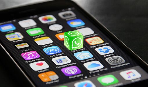 iPhone mit hervorgehobener App WhatsApp