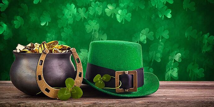 St. Patricks Day Hut und Topf mit Goldmünzen auf grün funkelnden Hintergrund