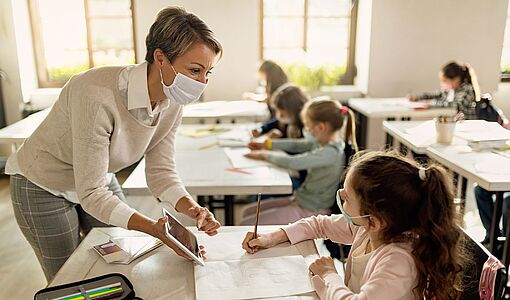 Lehrerin in Klasse mit Tablet