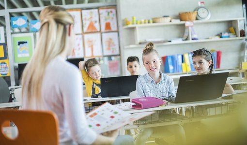 VERITAS Verlag Linz Schulklasse mit Lehrerin und Schulkindern