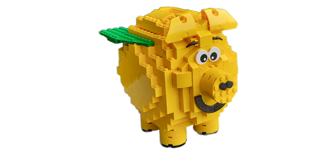Gelbe Schweinefigur aus LEGO-Steinen mit großen Augen und grüner Platte auf dem Rücken.
