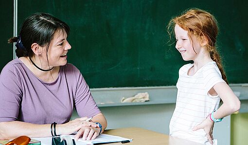 Kind spricht mit Lehrerin