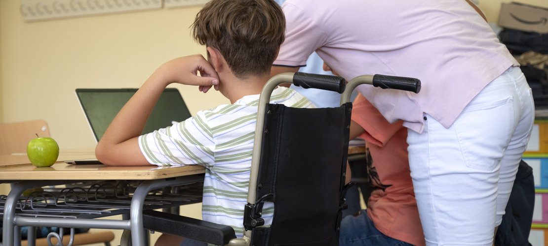 Bub in Rollstuhl in Klasse