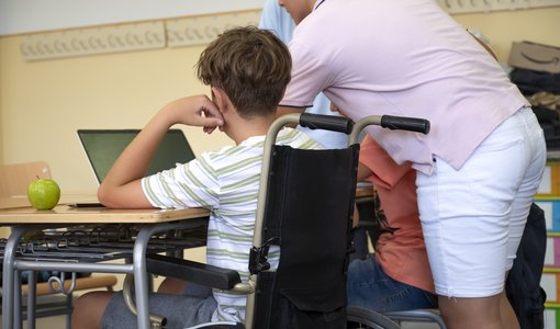 Bub in Rollstuhl in Klasse