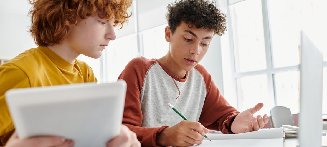 Schüler arbeiten an Laptop und Tablet