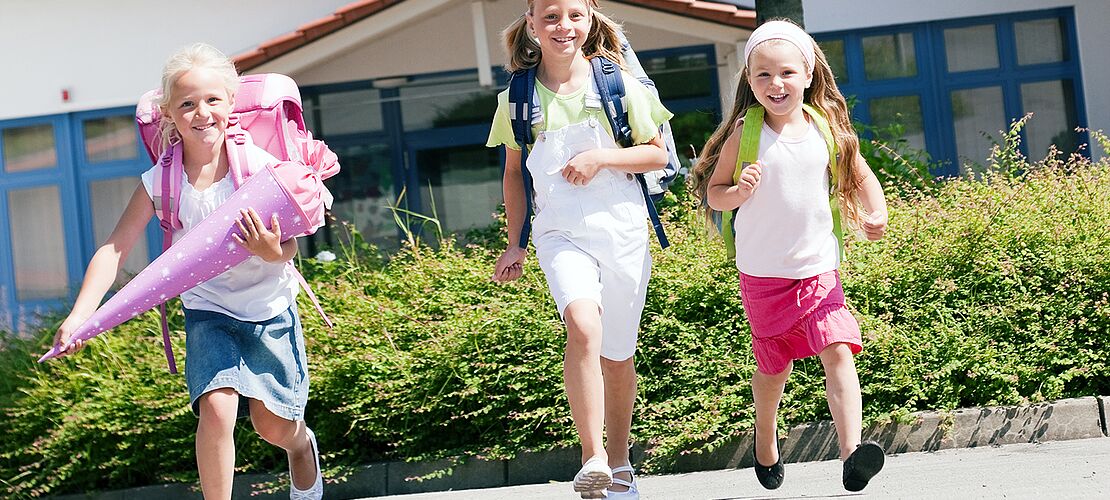 Kinder auf dem Weg zum ersten Schultag