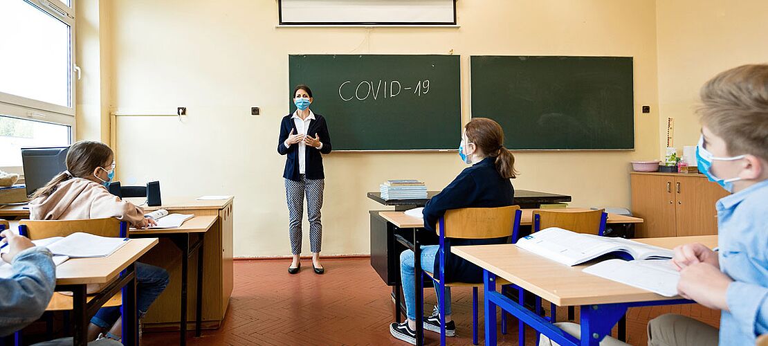 Lehrerin erklärt an der Tafel