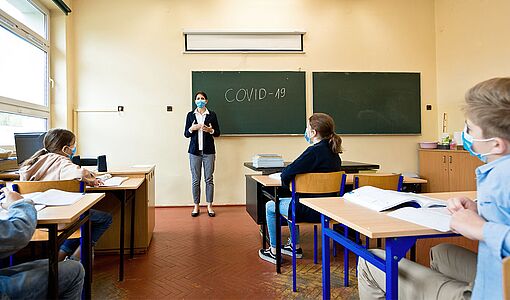 Lehrerin erklärt an der Tafel