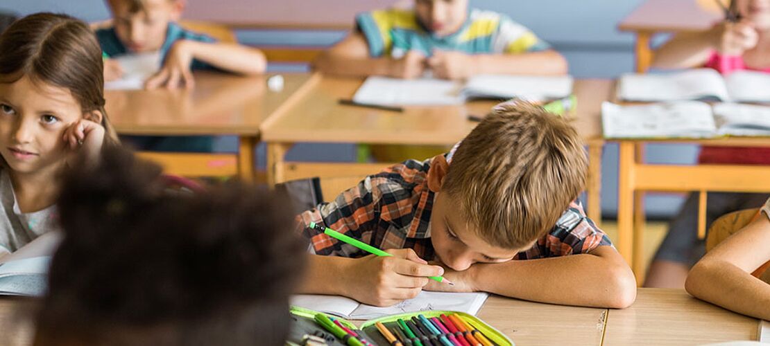 Müder Schüler in einer Schulklasse