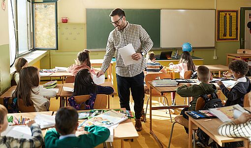 Lehrer verteilt Arbeiten an Schüler