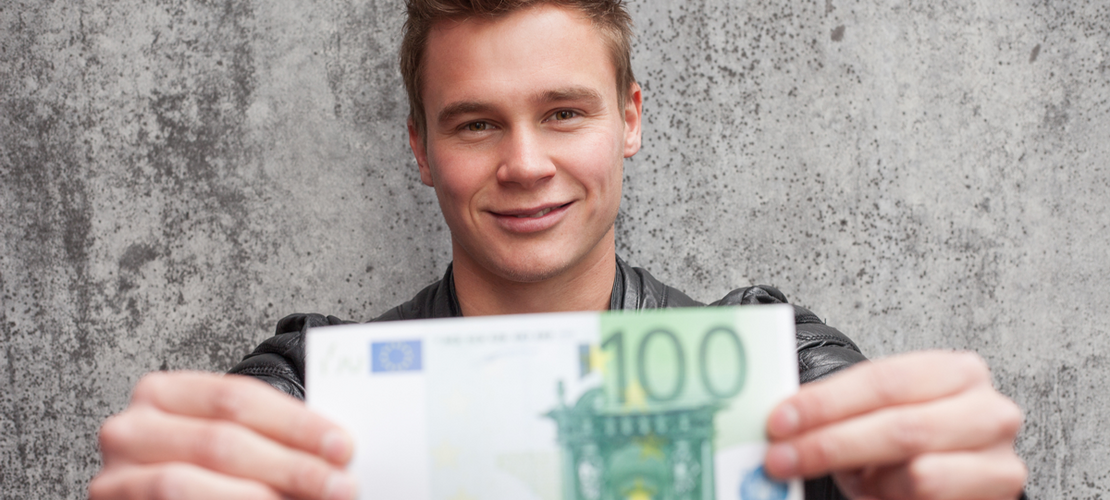 Junger Mann mit einem 100 € Schein in der Hand