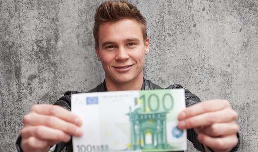 Junger Mann mit einem 100 € Schein in der Hand