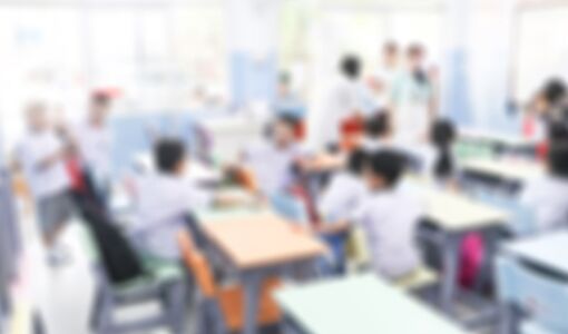 Verschwommene Grundschule mit Eltern und Kindern im Hintergrund