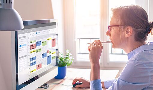 Frau blickt auf einen Terminkalender am Computer