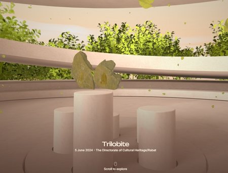 Returned Object - Trilobite Ein Stein mit fossilen Abdrücken liegt auf einem runden Sockel in einem offenen Raum mit grünen Pflanzen im Hintergrund.