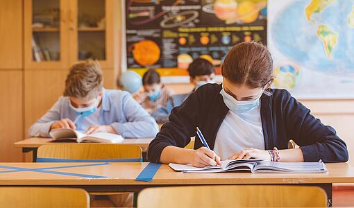 Schüler in der Klasse mit Maske