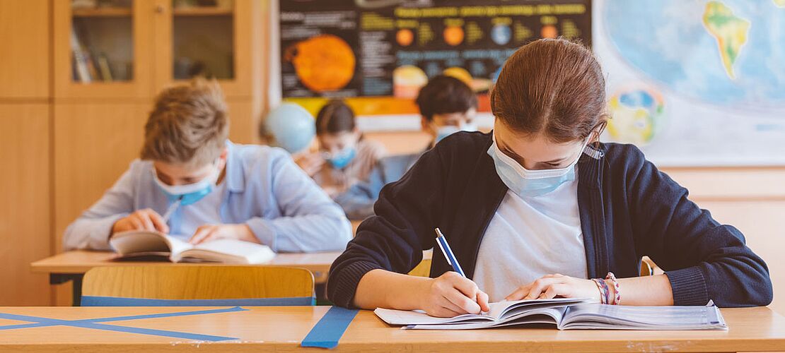 Schüler in der Klasse mit Maske