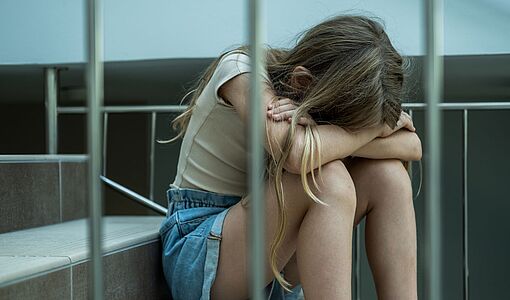 Trauriges Mädchen sitzt auf der Stiege