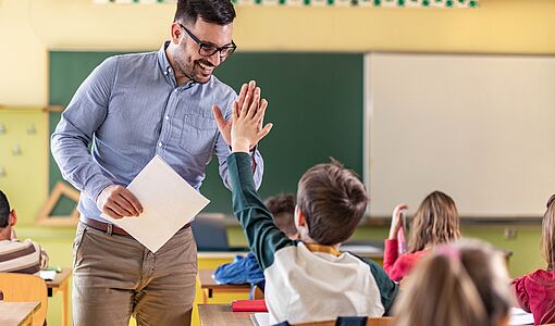 Lehrer klatscht in die Hände eines Schülers