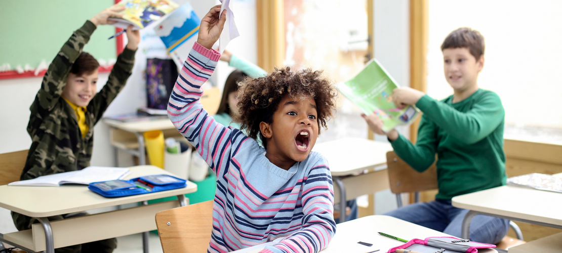 Kinder, die in einem Schulklassenzimmer ein Chaos anrichten